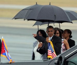epa05223329 US President Barack Obama (3-R) carries an umbrella as he is followed by First Lady Michelle Obama (2-R) after their arrival on Jose Marti Airport in Havana, Cuba, 20 March 2016. Others are not identified. Barack Obama arrives in Cuba for an official visit until 22 March to seal the process of rapprochement with the Communist-ruled island. Obama is accompanied by his wife Michelle, his daughters Malia and Sasha, and his mother-in-law Marian Robinson. The visit of Obama to Cuba from 20 to 22 March 2016 is the first visit of a US president to Cuba since US President Calvin Coolidge's visit 88 years ago. EPA/ALEJANDRO ERNESTO