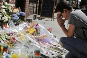 Zoe Feldman kneels in front of a makeshift memorial in front of New York's Stonewall Inn, Monday, June 13, 2016 to remember the victims of a mass shooting in Orlando, Fla. Morris was college friends with Kimberly Morris, who was working at the nightclub and died in the massacre. "A lot of my friends knew her and we all are just devastated," said Feldman. A gunman opened fire in a crowded Orlando nightclub early Sunday killing dozens of people. (ANSA/AP Photo/Mark Lennihan) [CopyrightNotice: Copyright 2016 The Associated Press. All rights reserved. This material may not be published, broadcast, rewritten or redistribu]